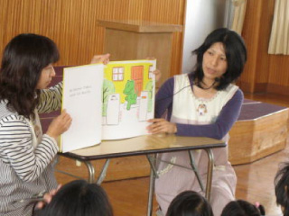 子育て広場の活動として絵本の読み聞かせを行うボランティアスタッフ